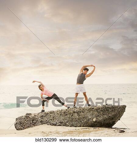 Caucasian runners stretching on beach View Large Photo Image Stock Photo - Caucasian runners stretching on beach. Fotosearch