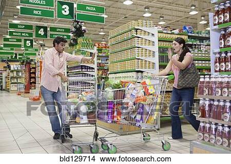 Caucasian shoppers crashing into each other at grocery store View Large Photo Image Picture - Caucasian shoppers crashing into each other at grocery store. Fotosearch