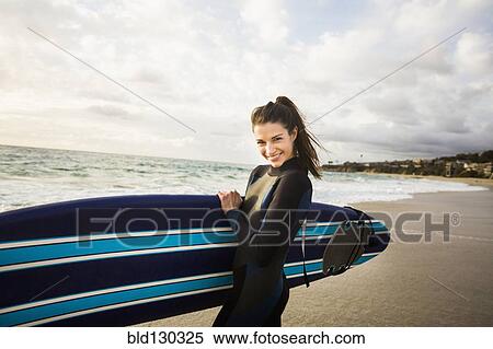 Caucasian surfer carrying board in surf View Large Photo Image Stock Photography - Caucasian surfer carrying board in surf. Fotosearch