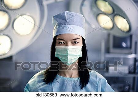 Caucasian surgeon wearing mask in operating room View Large Photo Image Stock Image - Caucasian surgeon wearing mask in operating room. Fotosearch