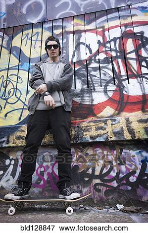 Caucasian teenage boy on skateboard by graffiti wall View Large Photo Image Stock Photo - Caucasian teenage boy on skateboard by graffiti wall. Fotosearch