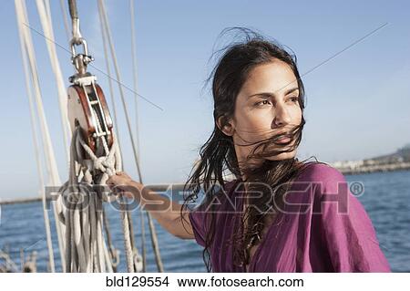 Caucasian woman hoisting sail on sailboat View Large Photo Image Picture - Caucasian woman hoisting sail on sailboat. Fotosearch