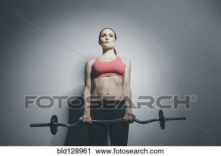 Stock Image - Caucasian woman holding barbell. Fotosearch