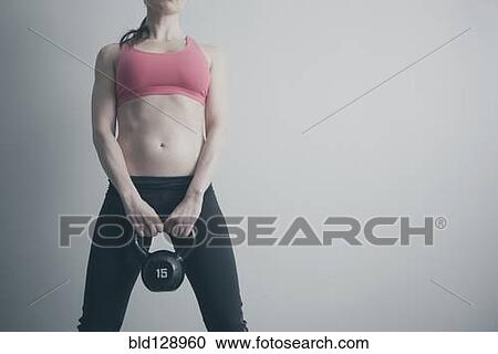 Caucasian woman holding kettle bell View Large Photo Image Stock Image - Caucasian woman holding kettle bell. Fotosearch