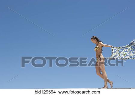Caucasian woman in bikini holding sarong in wind View Large Photo Image Picture - Caucasian woman in bikini holding sarong in wind. Fotosearch