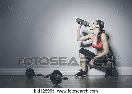 Caucasian woman in sportswear drinking from water bottle View Large Photo Image Stock Photography - Caucasian woman in sportswear drinking from water bottle. Fotosearch