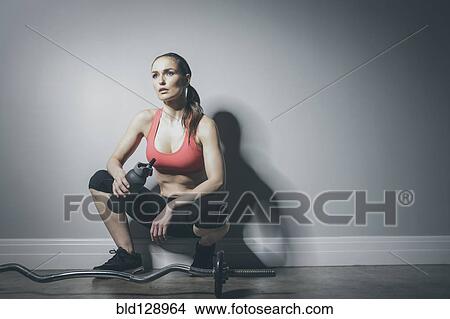 Caucasian woman in sportswear resting with water bottle View Large Photo Image Picture - Caucasian woman in sportswear resting with water bottle. Fotosearch