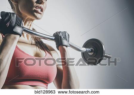Stock Image - Caucasian woman lifting barbell. Fotosearch