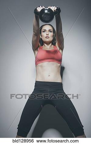 Caucasian woman lifting kettle bell View Large Photo Image Stock Photograph - Caucasian woman lifting kettle bell. Fotosearch