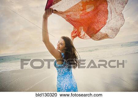 Stock Image - Caucasian woman playing on beach. Fotosearch