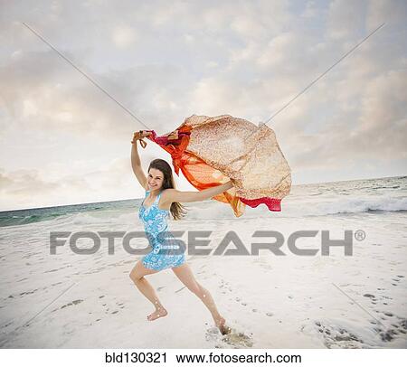 Stock Image - Caucasian woman playing on beach. Fotosearch