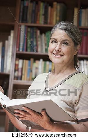 Caucasian woman reading book in library View Large Photo Image Stock Photo - Caucasian woman reading book in library. Fotosearch