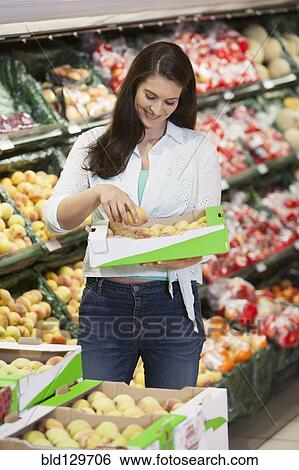 Caucasian woman shopping in grocery store View Large Photo Image Stock Photograph - Caucasian woman shopping in grocery store. Fotosearch
