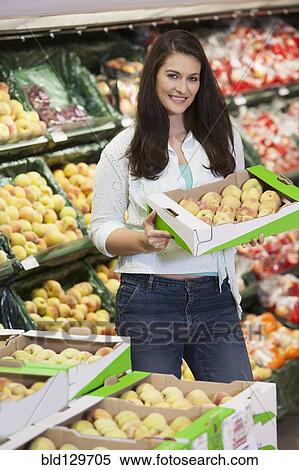 Stock Photography - Caucasian woman shopping in grocery store. Fotosearch