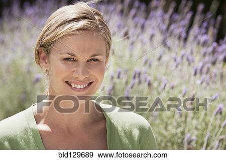 Stock Photo - Caucasian woman smiling in lavender field. Fotosearch