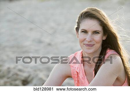 Stock Image - Caucasian woman smiling on beach. Fotosearch
