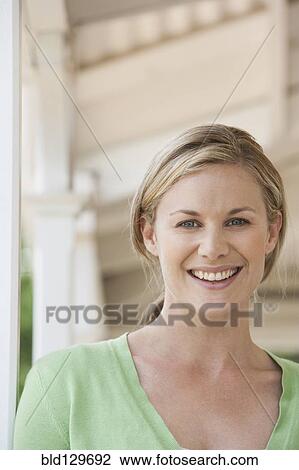 Caucasian woman smiling on porch View Large Photo Image Stock Image - Caucasian woman smiling on porch. Fotosearch