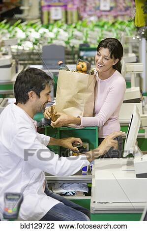 Caucasian woman talking to clerk in grocery store View Large Photo Image Stock Image - Caucasian woman talking to clerk in grocery store. Fotosearch