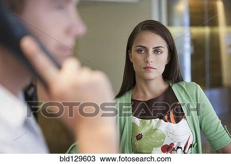 Caucasian woman watching boyfriend talk on cell phone View Large Photo Image Stock Image - Caucasian woman watching boyfriend talk on cell phone. Fotosearch