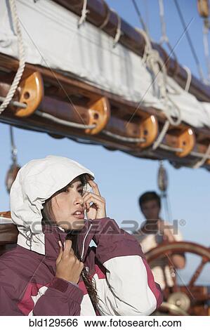 Stock Photograph - Caucasian woman wearing jacket on sailboat. Fotosearch