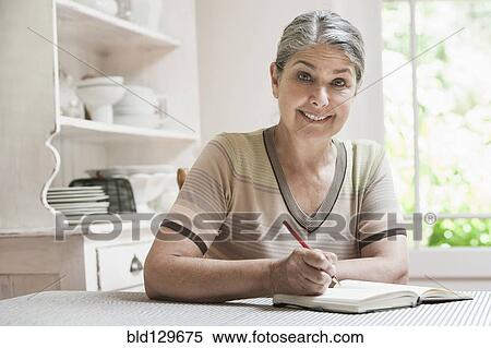 Stock Photography - Caucasian woman writing in journal. Fotosearch