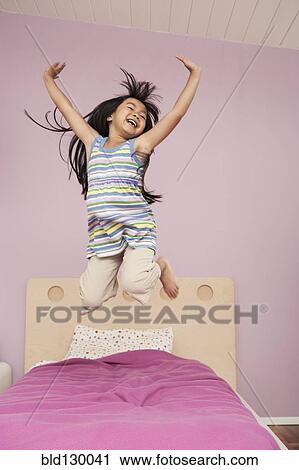 Chinese girl jumping on bed View Large Photo Image Stock Image - Chinese girl jumping on bed. Fotosearch
