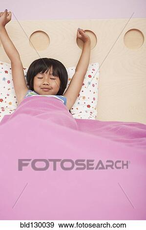 Chinese girl laying in bed View Large Photo Image Stock Photo - Chinese girl laying in bed. Fotosearch