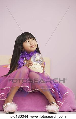 Chinese girl playing with snow globe View Large Photo Image Picture - Chinese girl playing with snow globe. Fotosearch