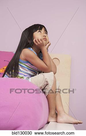 Chinese girl sitting on bed View Large Photo Image Stock Image - Chinese girl sitting on bed. Fotosearch