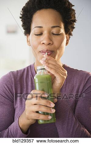 Close up of Black woman drinking green smoothie View Large Photo Image Stock Photo - Close up of Black woman drinking green smoothie. Fotosearch