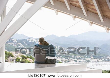 Stock Photo - Couple admiring view from balcony. Fotosearch