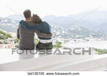 Stock Photography - Couple admiring view from balcony. Fotosearch