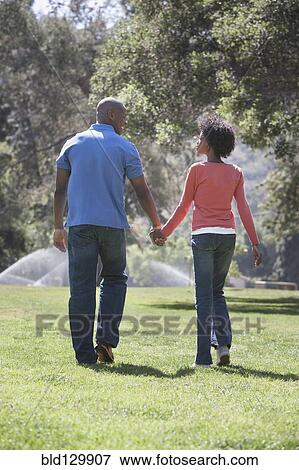 Stock Photo - Couple holding hands in park. Fotosearch