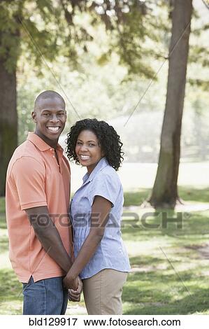 Couple holding hands in park View Large Photo Image Stock Photo - Couple holding hands in park. Fotosearch