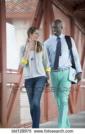 Stock Photography - Couple holding hands on walkway. Fotosearch