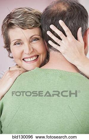 Stock Photograph - Couple hugging indoors. Fotosearch