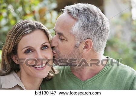 Stock Photo - Couple kissing outdoors. Fotosearch