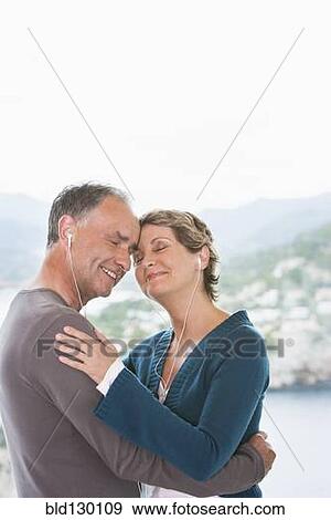 Stock Photo - Couple listening to earphones together. Fotosearch