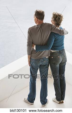 Couple overlooking view from balcony View Large Photo Image Stock Image - Couple overlooking view from balcony. Fotosearch