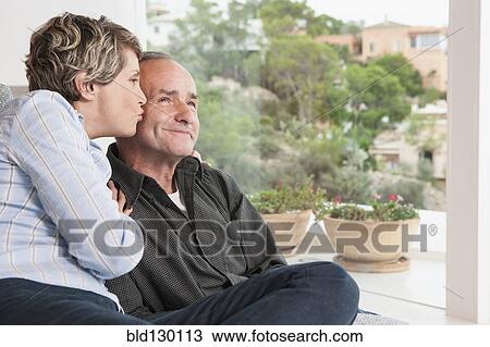Couple relaxing together in living room View Large Photo Image Stock Image - Couple relaxing together in living room. Fotosearch