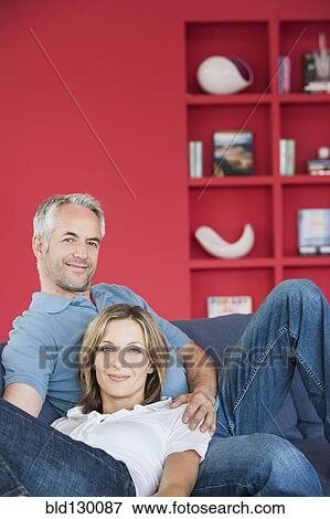 Couple relaxing together in living room View Large Photo Image Stock Photo - Couple relaxing together in living room. Fotosearch
