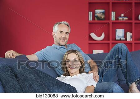 Couple relaxing together in living room View Large Photo Image Stock Photo - Couple relaxing together in living room. Fotosearch