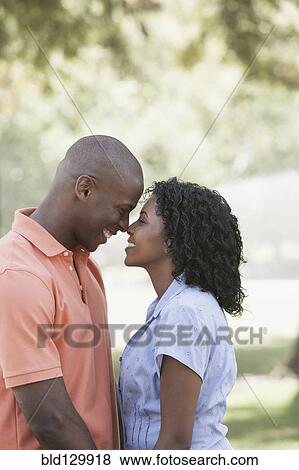 Stock Photo - Couple rubbing noses in park. Fotosearch