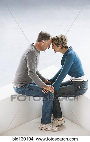 Picture - Couple sitting together outdoors. Fotosearch