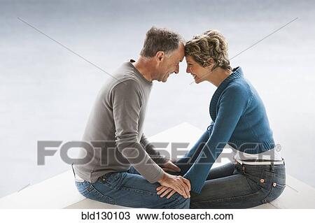 Stock Image - Couple sitting together outdoors. Fotosearch