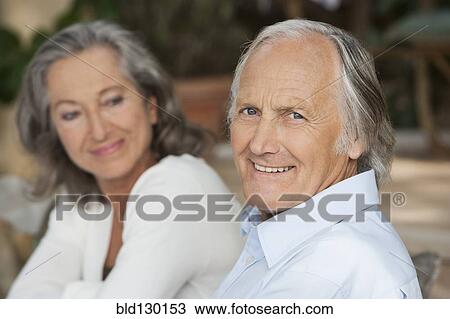Couple sitting together outdoors View Large Photo Image Stock Image - Couple sitting together outdoors. Fotosearch