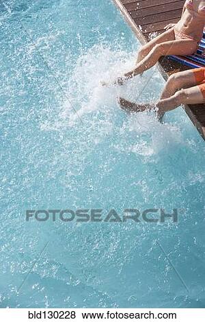 Stock Photo - Couple splashing in swimming pool. Fotosearch
