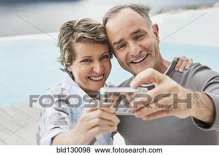 Couple taking picture together outdoors View Large Photo Image Stock Photo - Couple taking picture together outdoors. Fotosearch