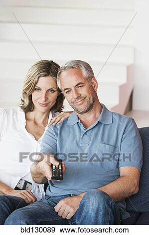 Couple watching television in living room View Large Photo Image Stock Photo - Couple watching television in living room. Fotosearch