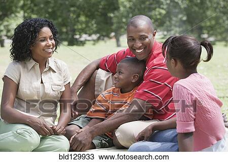 Family relaxing together in park View Large Photo Image Stock Image - Family relaxing together in park. Fotosearch